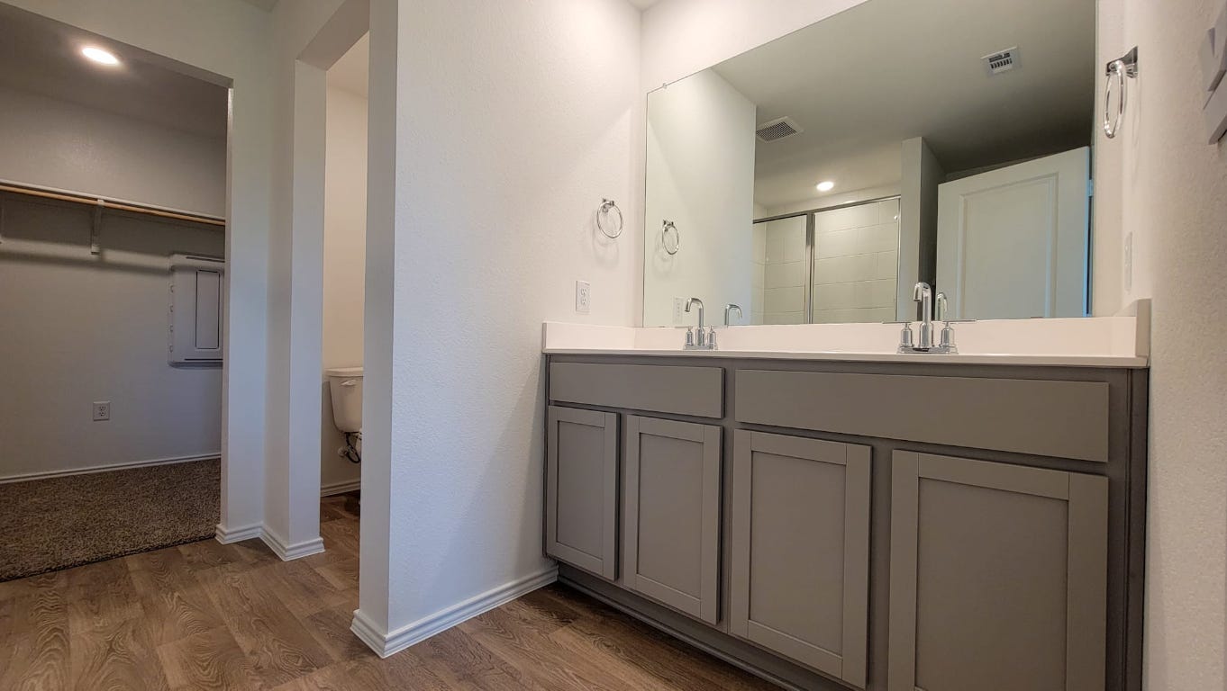245 Texoma Street Kyle, TX 78640 - Photo 8 of 17 a bathroom with a double vanity sink and mirror