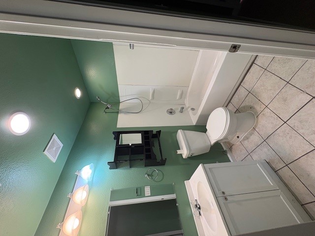 606 Guadalimar Street Lockhart, TX 78644 - Photo 8 of 11 a bathroom with a sink a toilet a mirror and bathtub