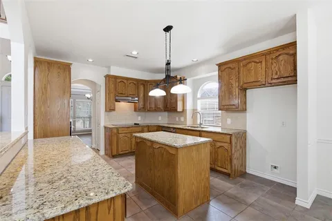 a kitchen with granite countertop sink stove and cabinets