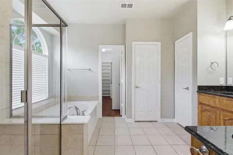 a spacious bathroom with a granite countertop sink a toilet a mirror and shower