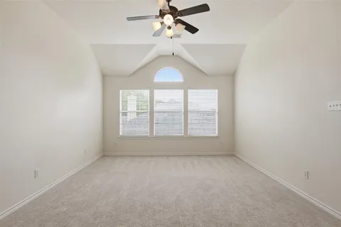 an empty room with a window and a fan