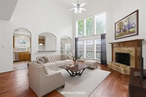 a view of a livingroom with wooden floor a fireplace and windows
