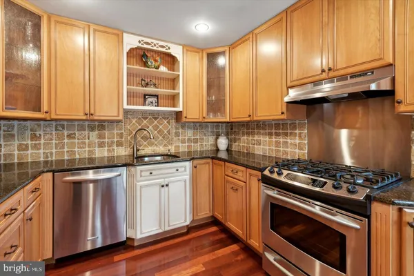 a kitchen with stainless steel appliances a stove a sink and cabinets