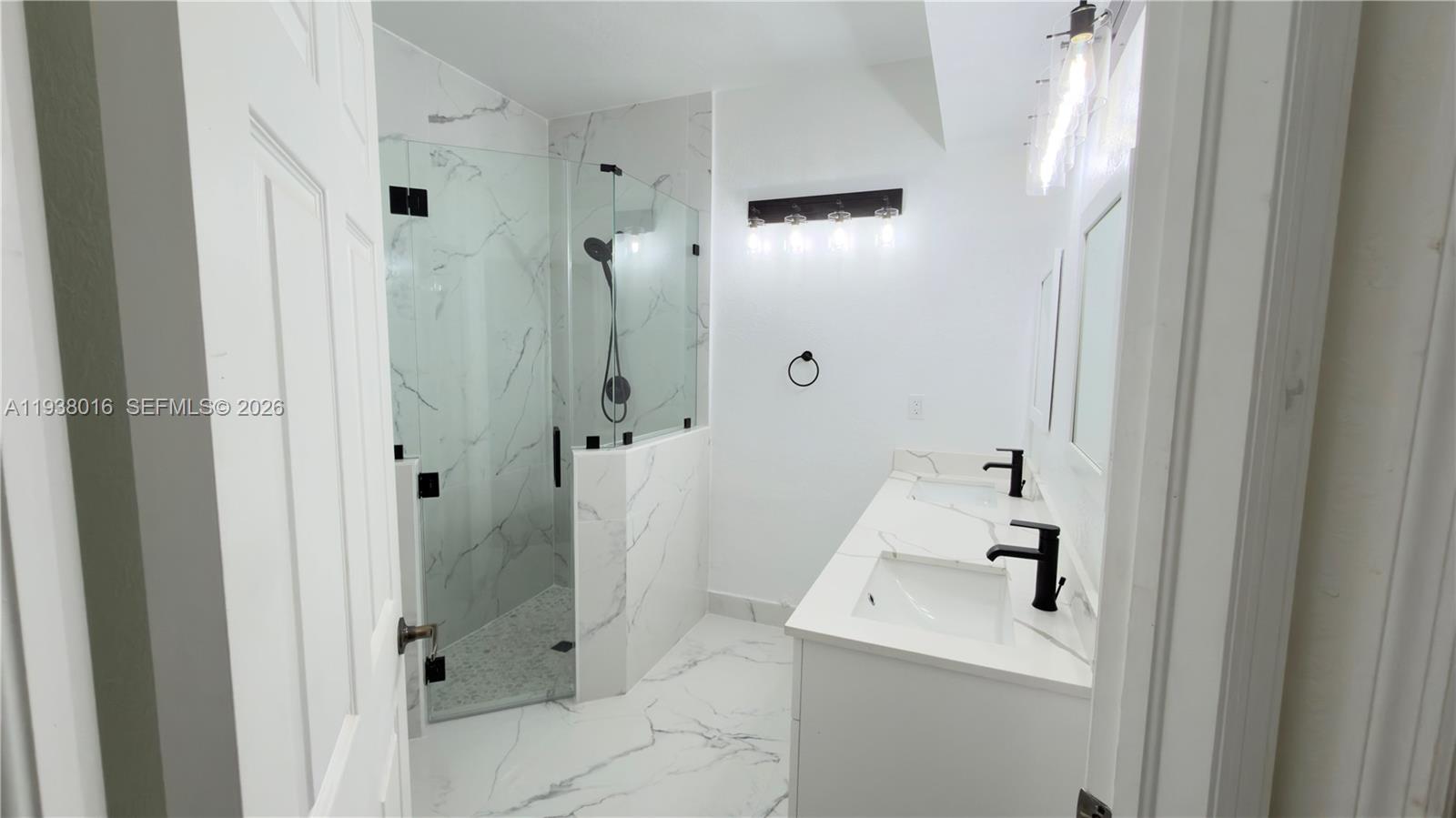 7633 Northwest 114th Path, Unit 7633 Doral, FL 33178 - Photo 25 of 30 a bathroom with a sink a mirror and shower