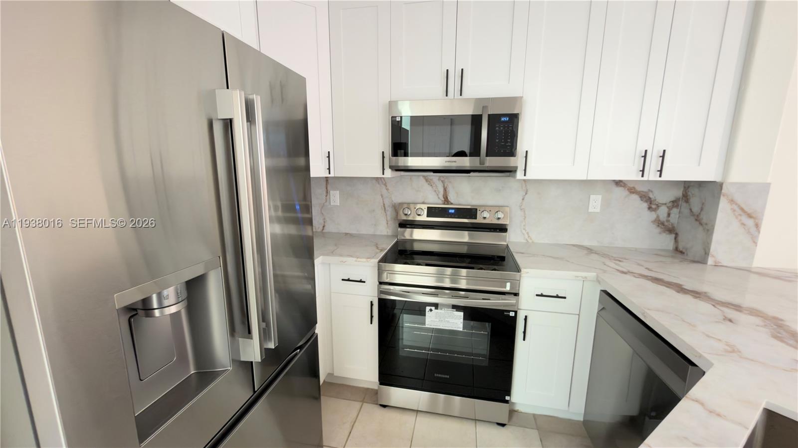 7633 Northwest 114th Path, Unit 7633 Doral, FL 33178 - Photo 29 of 30 a kitchen with a stove microwave and refrigerator