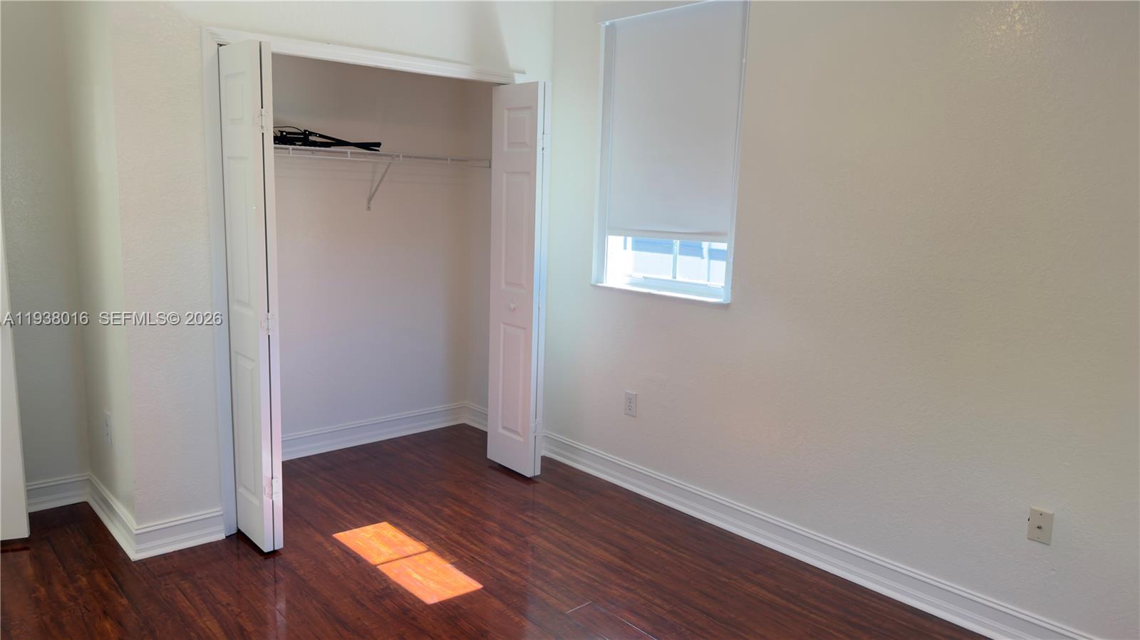 7633 Northwest 114th Path, Unit 7633 Doral, FL 33178 - Photo 4 of 30 an empty room with wooden floor and windows