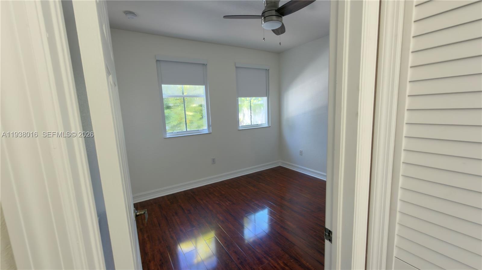 7633 Northwest 114th Path, Unit 7633 Doral, FL 33178 - Photo 6 of 30 an empty room with wooden floor fan and windows