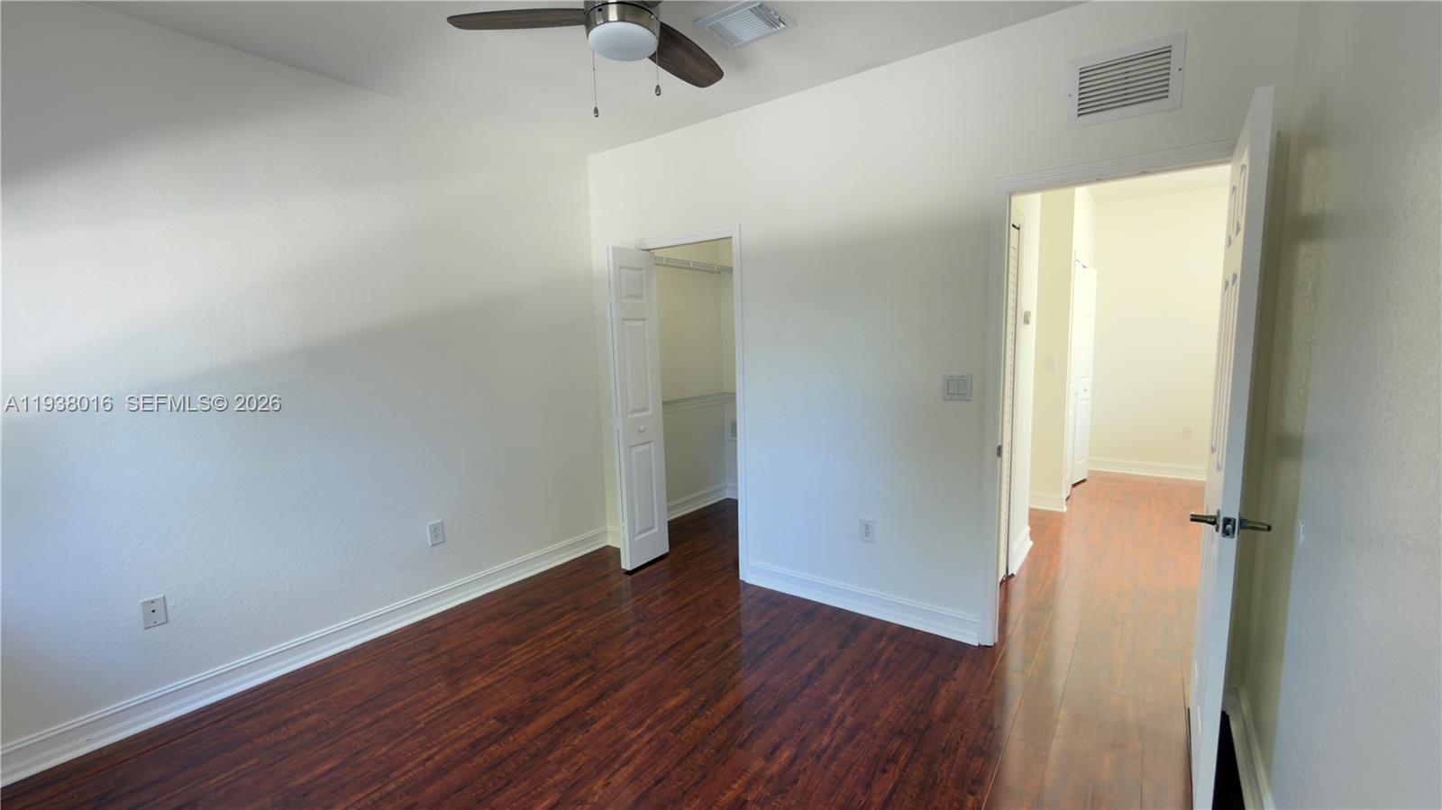 7633 Northwest 114th Path, Unit 7633 Doral, FL 33178 - Photo 7 of 30 an empty room with wooden floor and a window