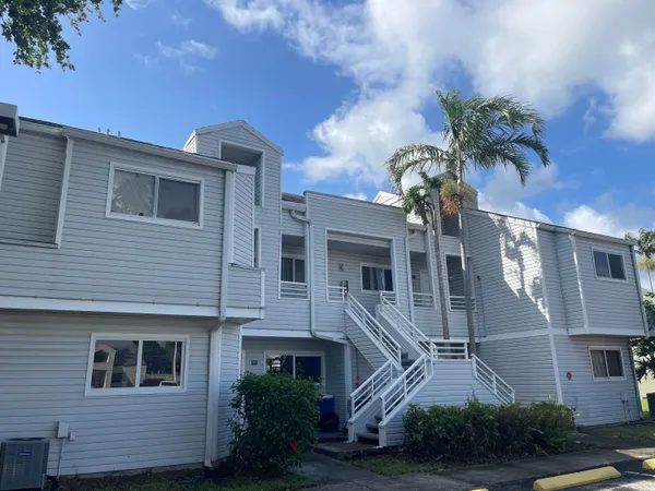 a view of a house with a yard and potted plants