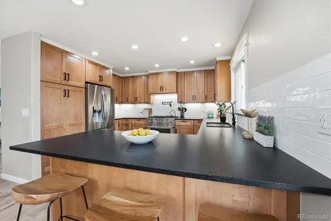 a kitchen with stainless steel appliances granite countertop a sink refrigerator and cabinets