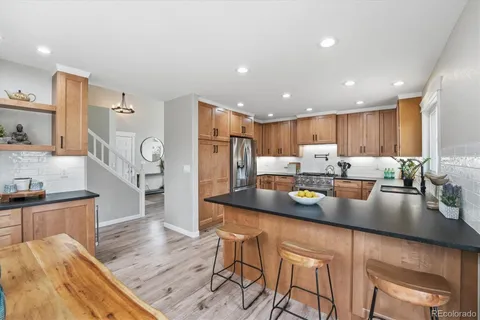 a kitchen with stainless steel appliances granite countertop a sink refrigerator and cabinets