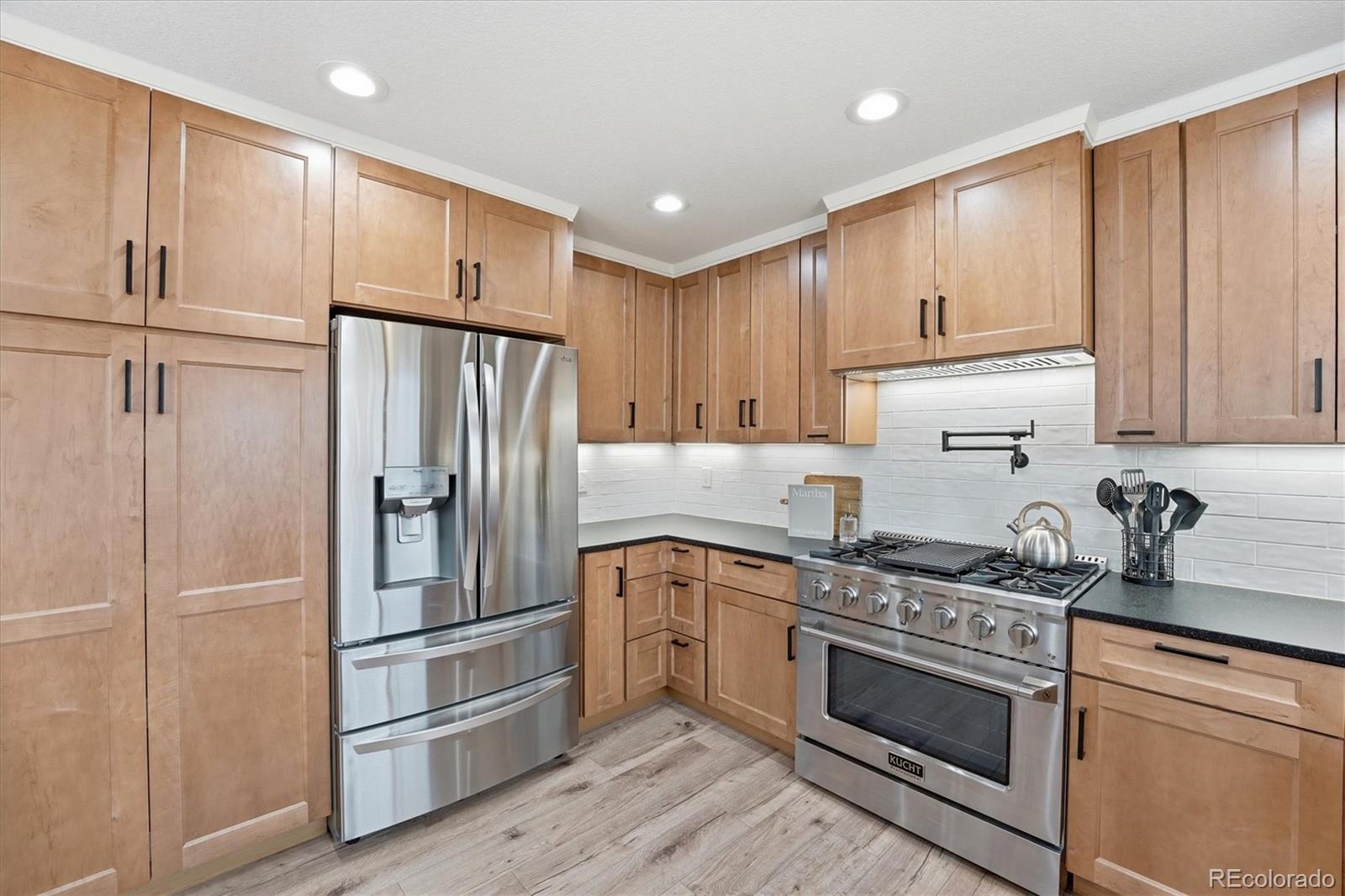 9387 Wolfe Drive Highlands Ranch, CO 80129 - Photo 16 of 50 a kitchen with a refrigerator stove and cabinets