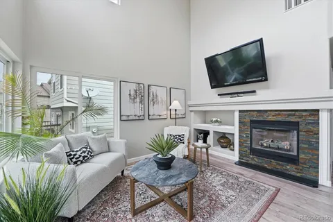 a living room with furniture a flat screen tv and a fireplace