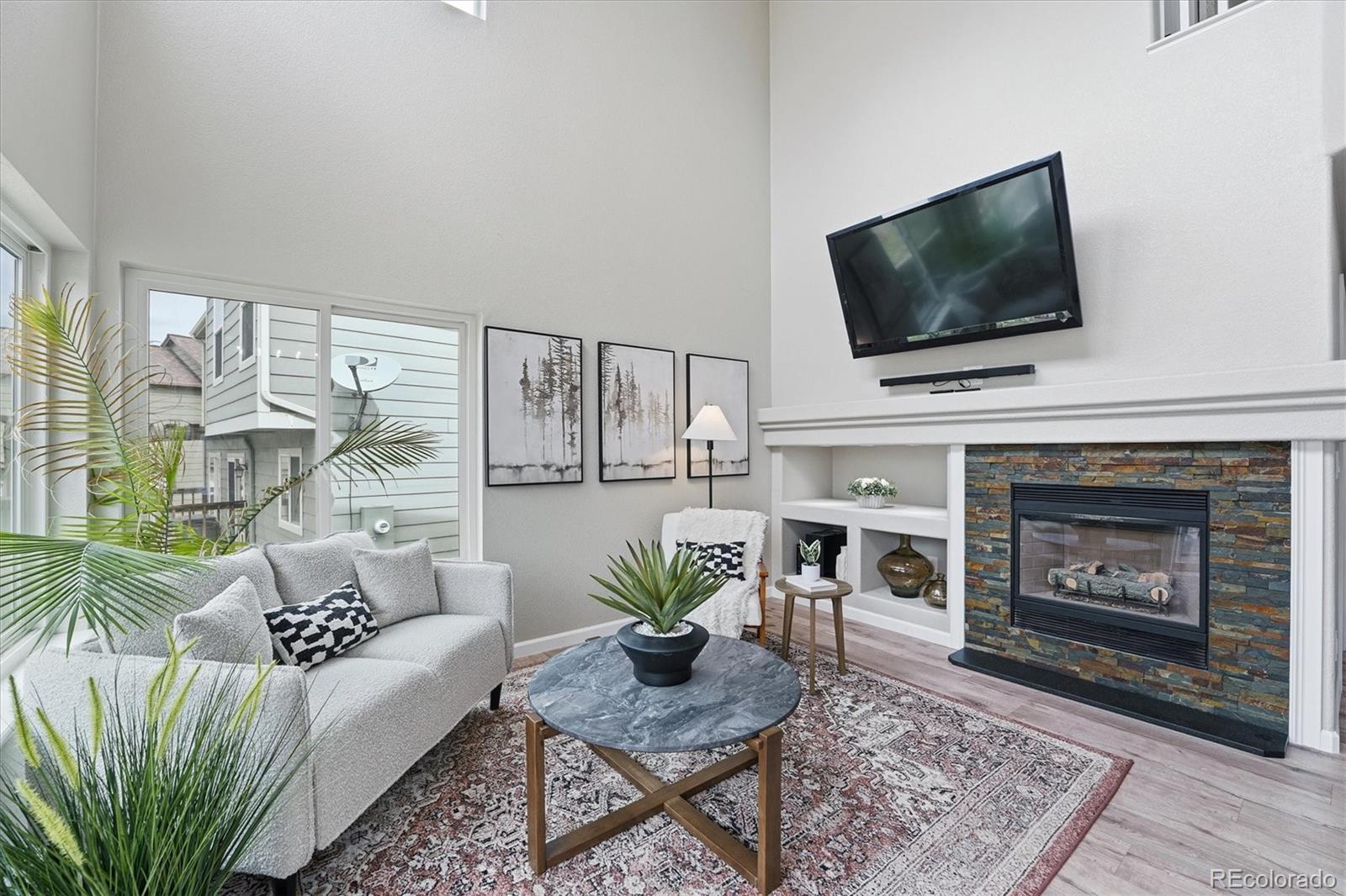 9387 Wolfe Drive Highlands Ranch, CO 80129 - Photo 19 of 50 a living room with furniture a flat screen tv and a fireplace