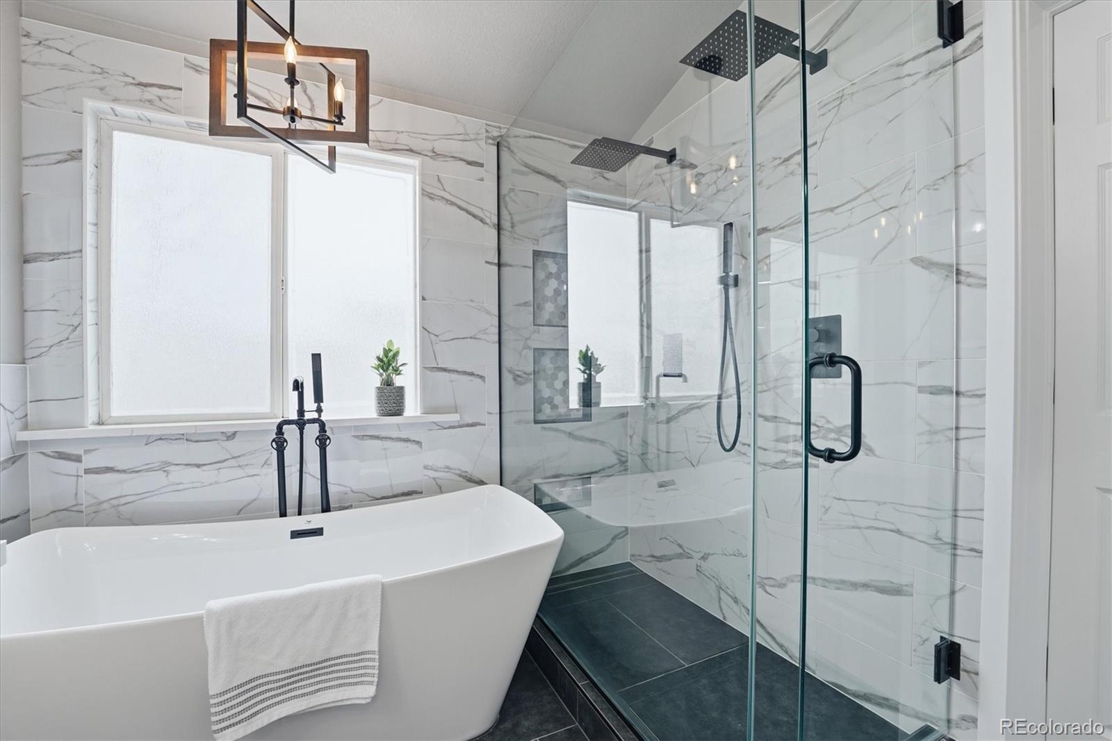 9387 Wolfe Drive Highlands Ranch, CO 80129 - Photo 32 of 50 a bathroom with a sink and mirror with bathtub
