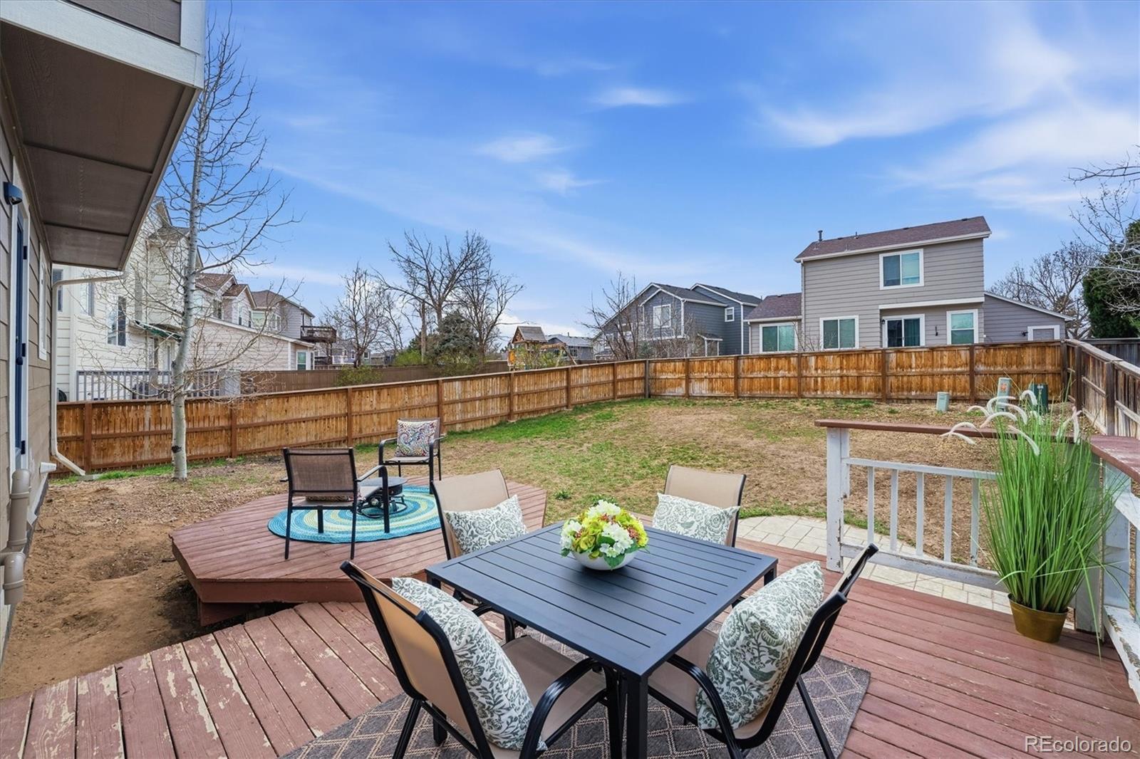 9387 Wolfe Drive Highlands Ranch, CO 80129 - Photo 45 of 50 a view of a patio with couches table and chairs with wooden floor and fence