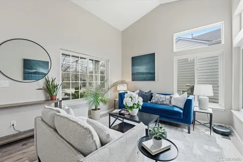 a living room with furniture a window and a potted plant