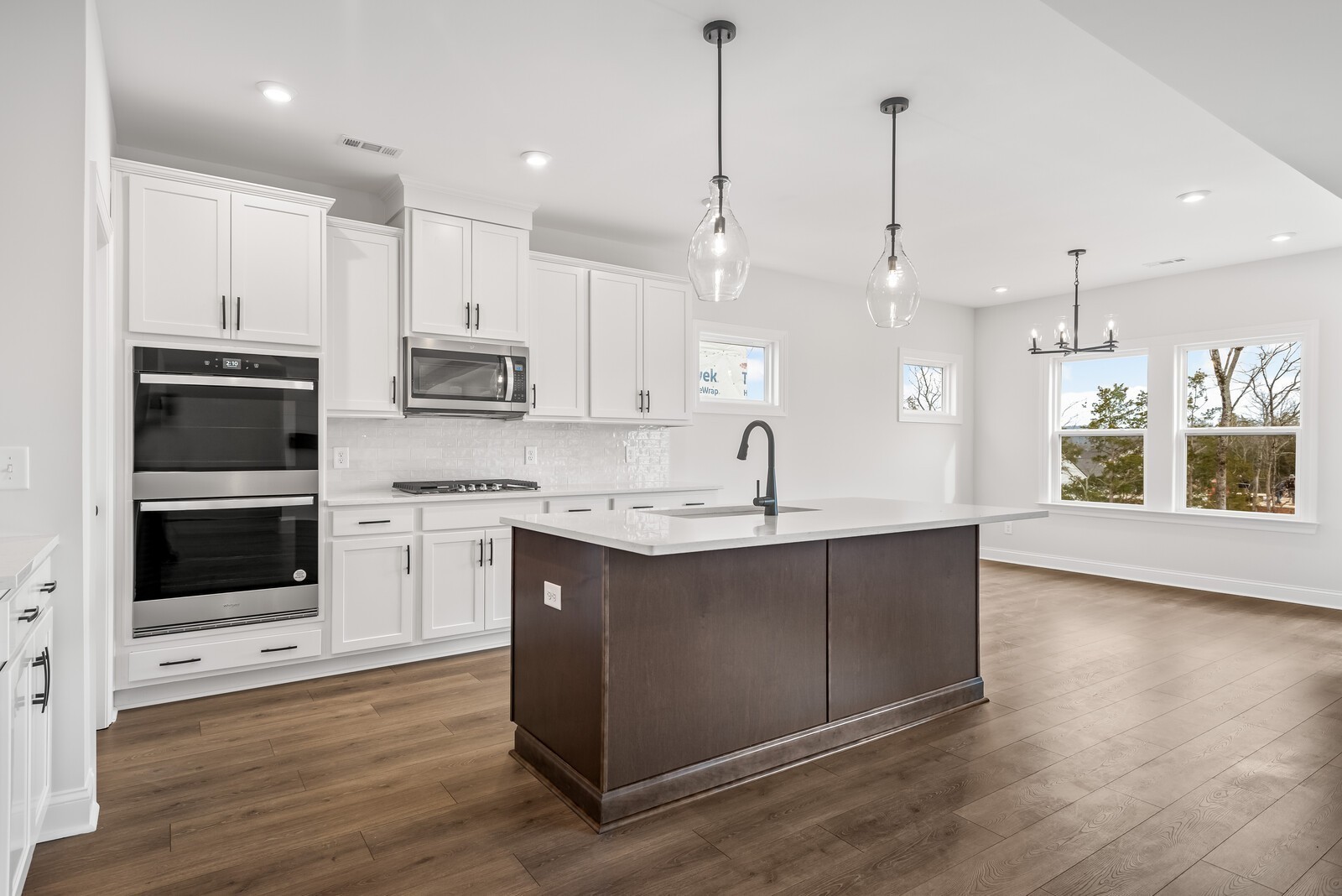 a kitchen with stainless steel appliances kitchen island a sink a stove and a wooden floor