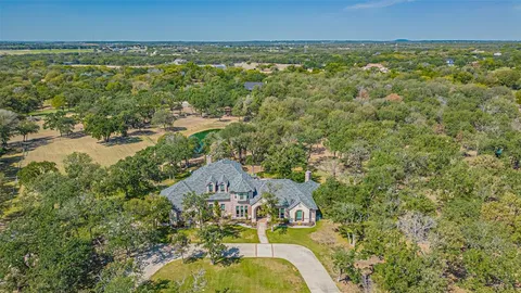 an aerial view of residential houses with outdoor space and trees