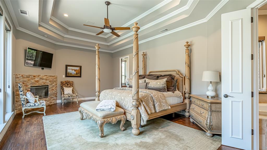 400 Porter Road Bartonville, TX 76226 - Photo 15 of 40 a bedroom with a bed wooden floor and a fireplace