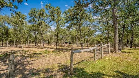 a view of a yard with wooden fence