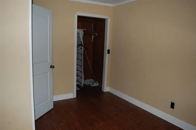 an empty room with wooden floor and closet