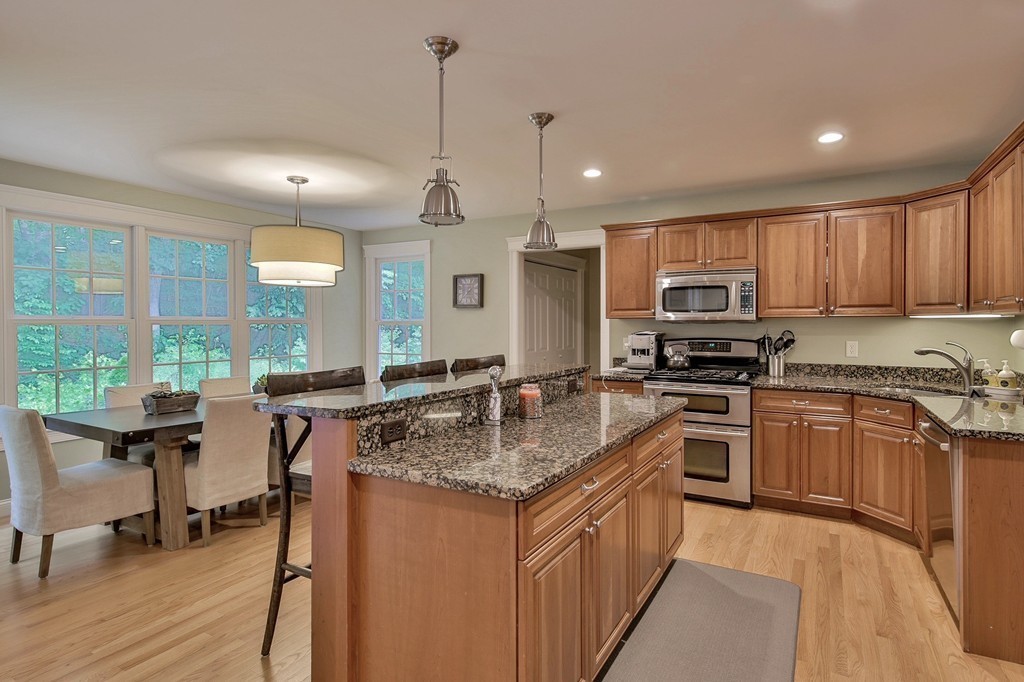 5 Wilkes Road Rowley, MA 01969 - Photo 7 of 25 a kitchen with stainless steel appliances granite countertop wooden cabinets a stove a sink and a wooden floors