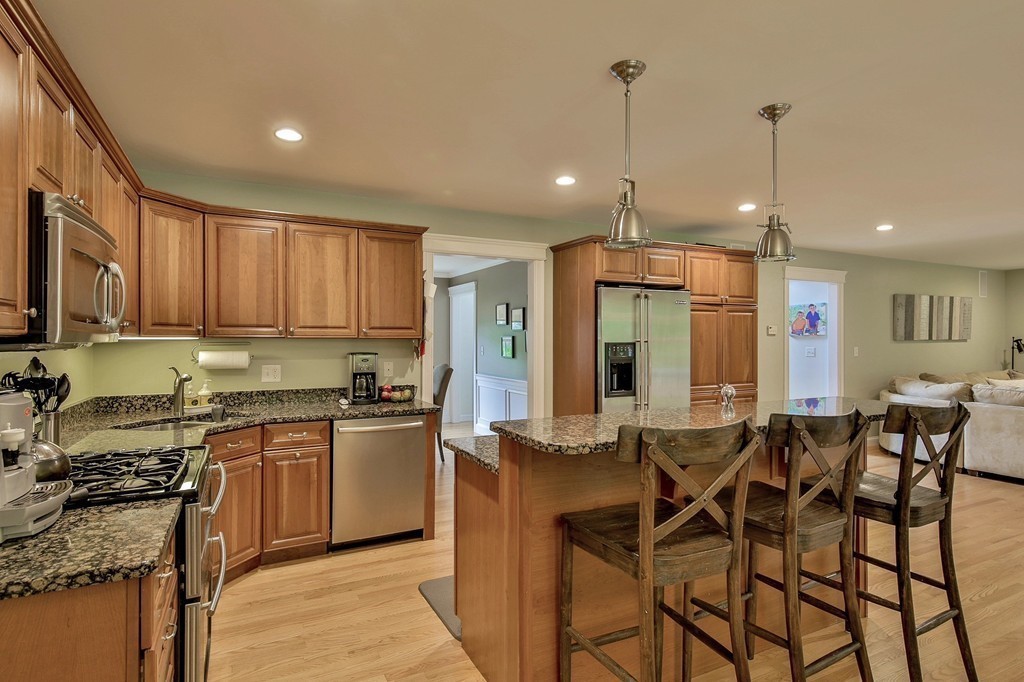 5 Wilkes Road Rowley, MA 01969 - Photo 8 of 25 a kitchen with stainless steel appliances granite countertop a stove top oven a refrigerator a sink and chairs