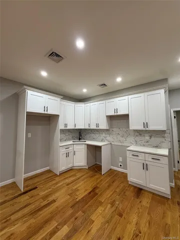 a kitchen with a refrigerator and white cabinets
