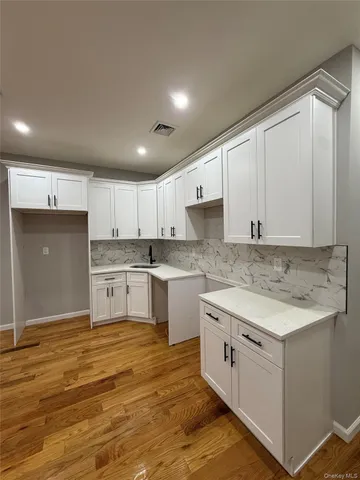 a kitchen with granite countertop white cabinets and white appliances