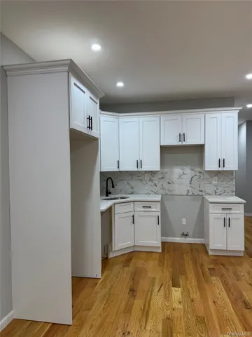 a kitchen with granite countertop a sink cabinets stainless steel appliances and a counter top space