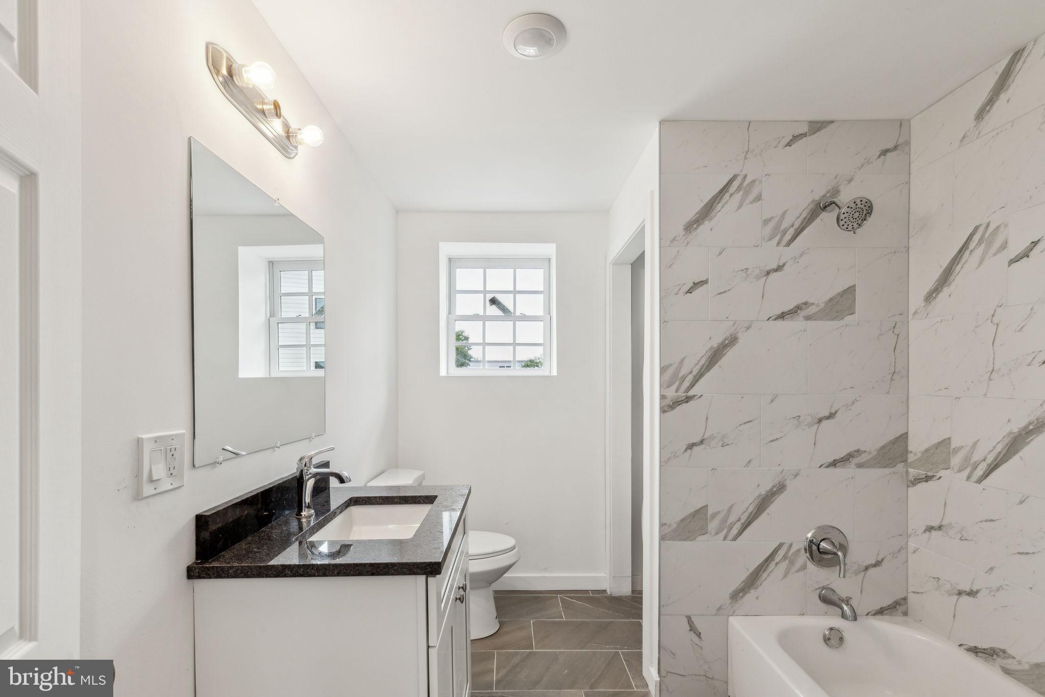 7039 Ridge Avenue Philadelphia, PA 19128 - Photo 11 of 26 a bathroom with a granite countertop sink with a bathtub