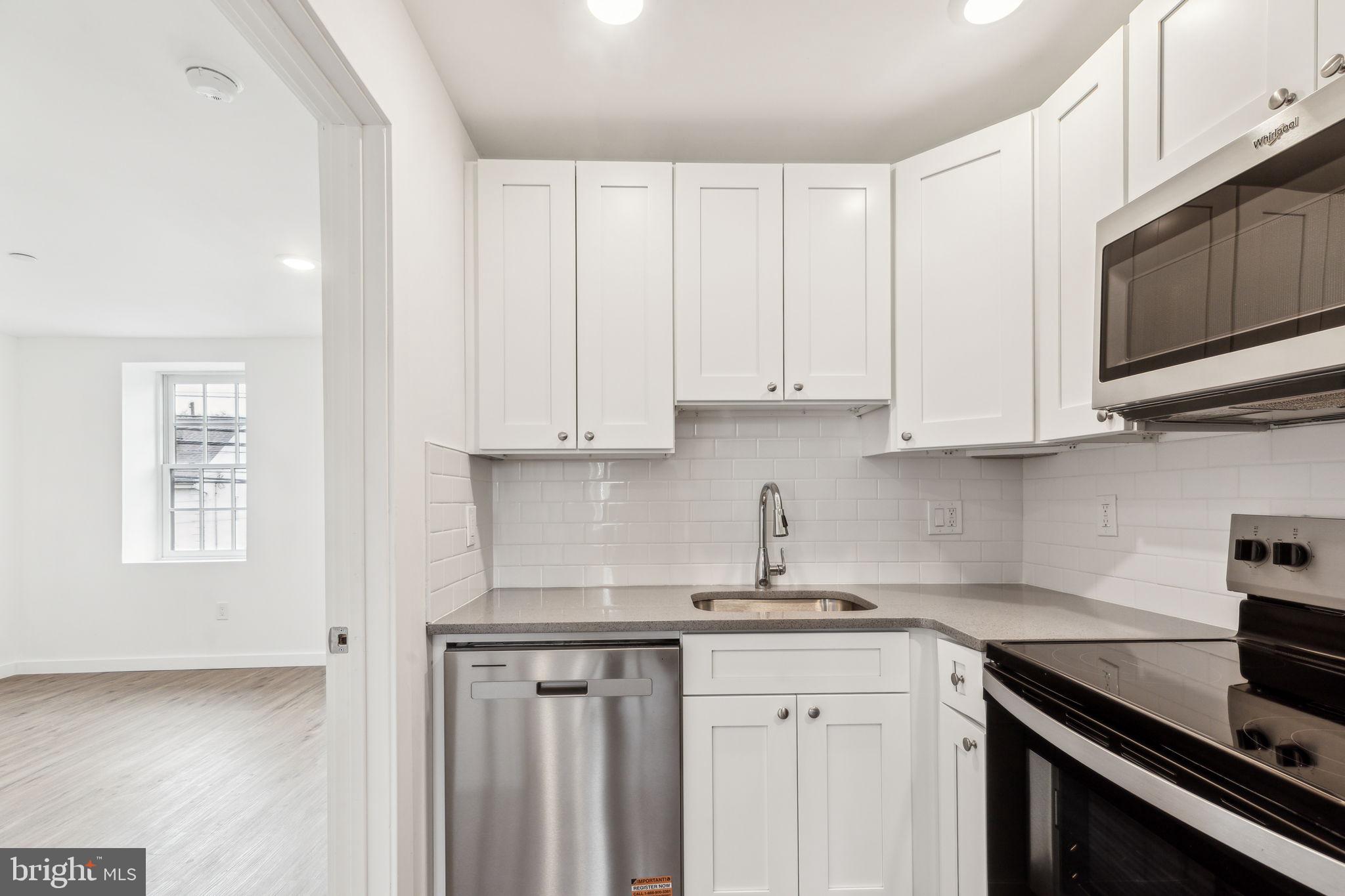 7039 Ridge Avenue Philadelphia, PA 19128 - Photo 18 of 26 a kitchen with stainless steel appliances granite countertop white cabinets sink and dishwasher