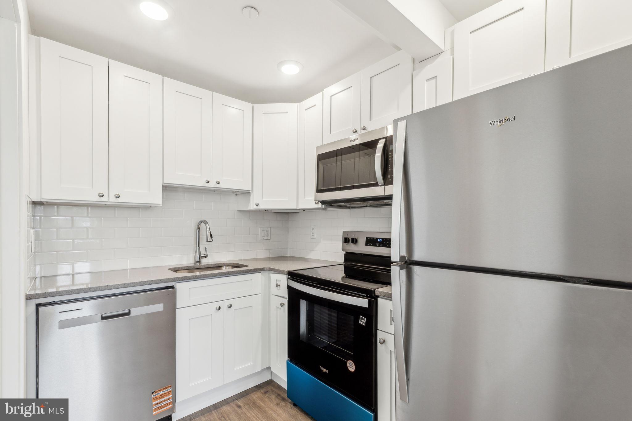 7039 Ridge Avenue Philadelphia, PA 19128 - Photo 19 of 26 a kitchen with stainless steel appliances white cabinets and a sink