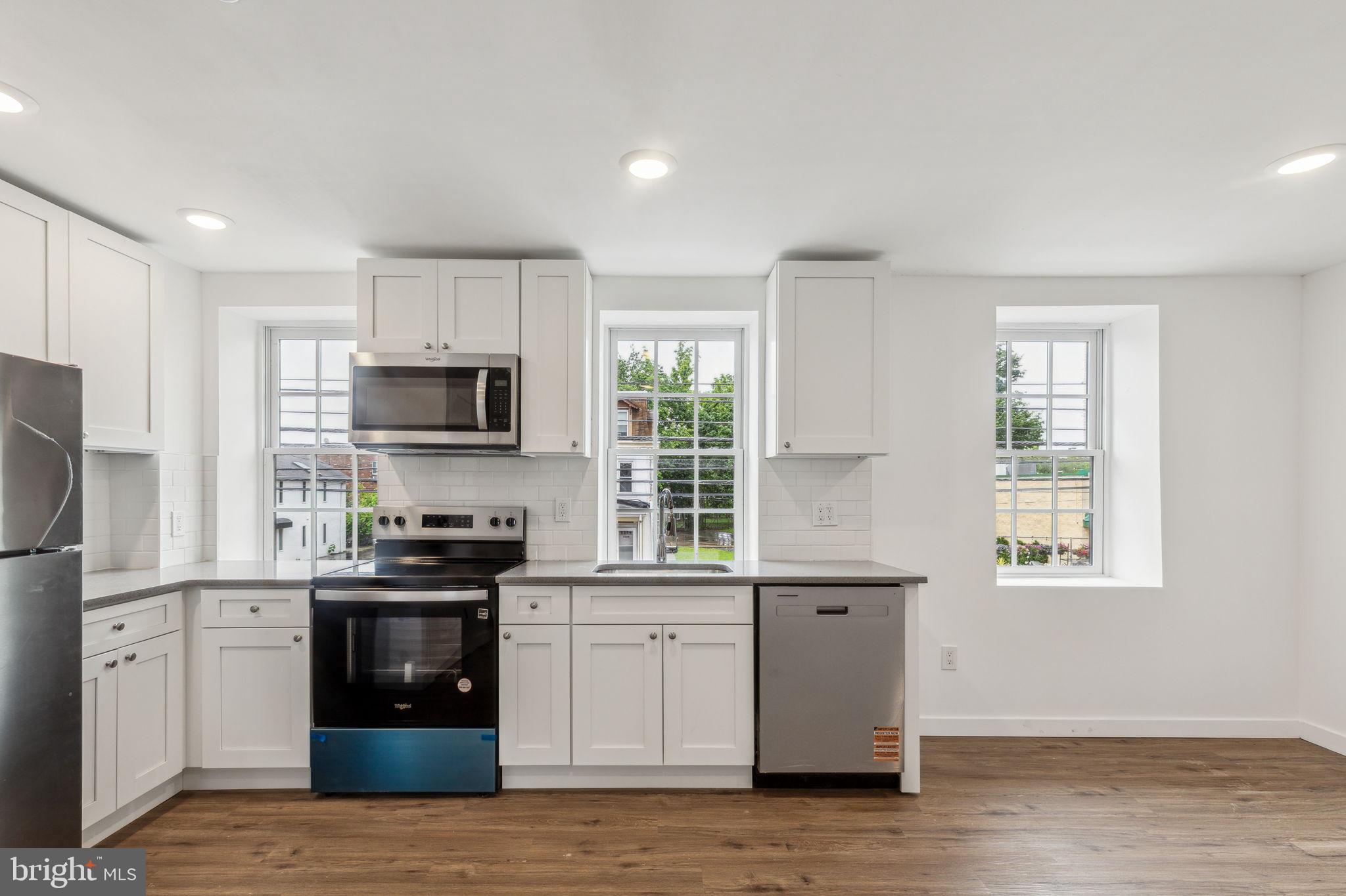 7039 Ridge Avenue Philadelphia, PA 19128 - Photo 5 of 26 a kitchen with stainless steel appliances a stove sink and microwave