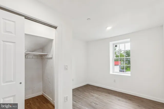 an empty room with wooden floor and a window