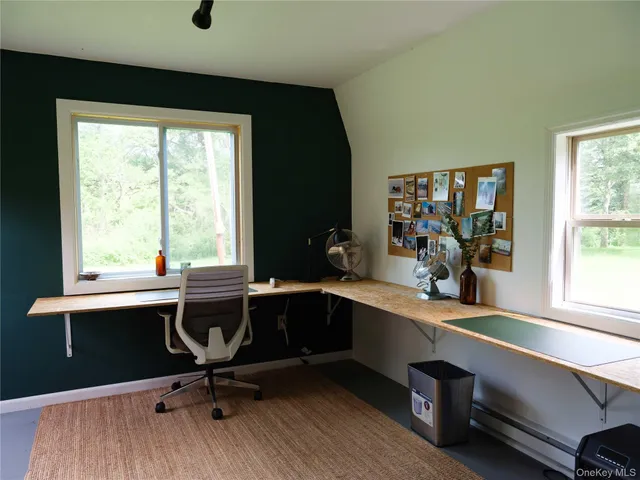 a view of a workspace with furniture and a window