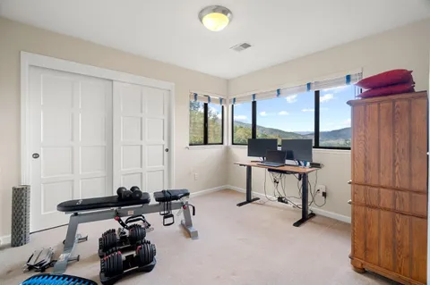 a view of a workspace with furniture and a window