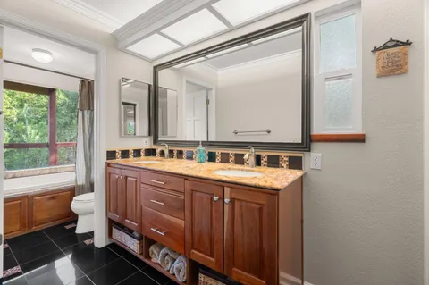 a bathroom with a granite countertop sink mirror and a toilet