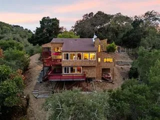 an aerial view of a house with a garden and trees
