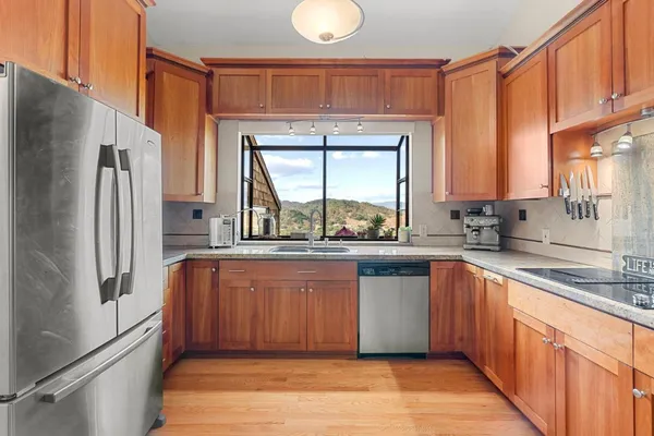 a kitchen with stainless steel appliances granite countertop a refrigerator and a sink