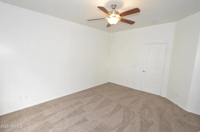 an empty room with a window and a ceiling fan