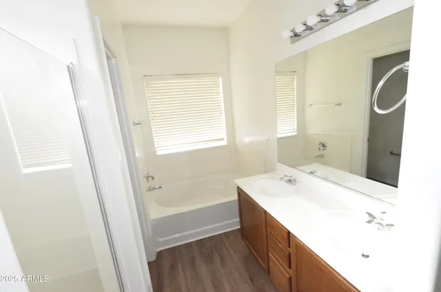 a bathroom with a tub sink and mirror
