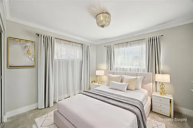 a bedroom with a large bed and a chandelier