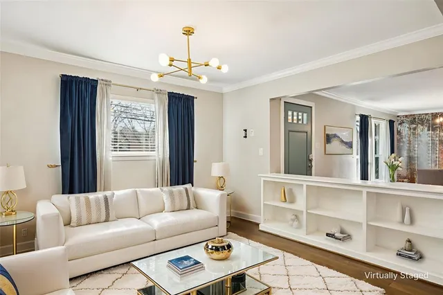 a living room with furniture a chandelier and a window
