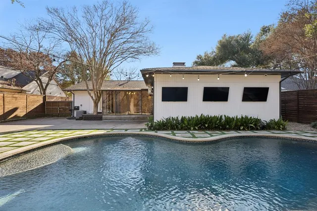 a front view of a house with a yard and a large tree