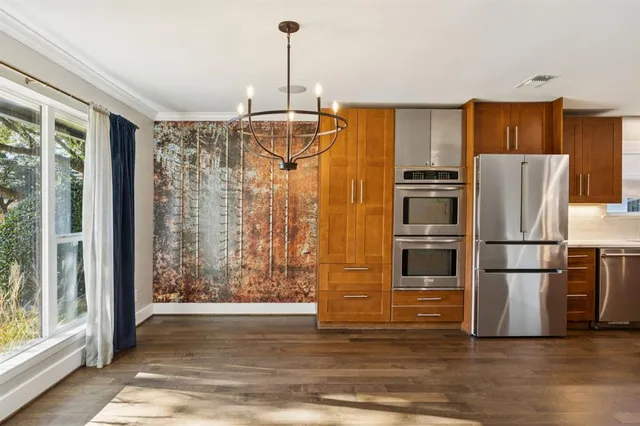 a kitchen with granite countertop a refrigerator and a wooden floor