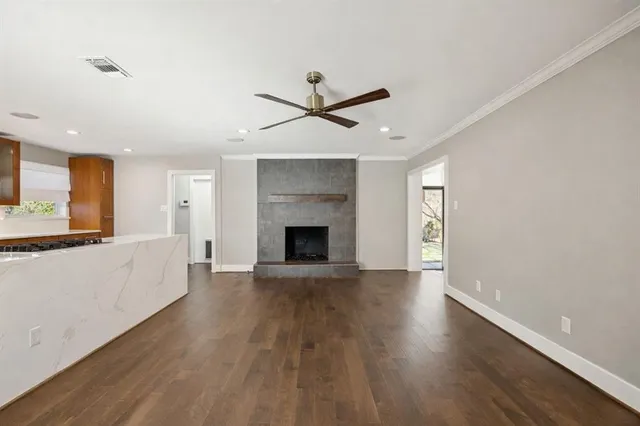 a view of an empty room with a kitchen and a window