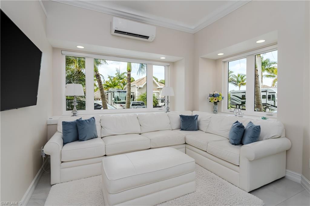 13410 Snook Circle Naples, FL 34114 - Photo 14 of 50 a living room with furniture a large window and a flat screen tv