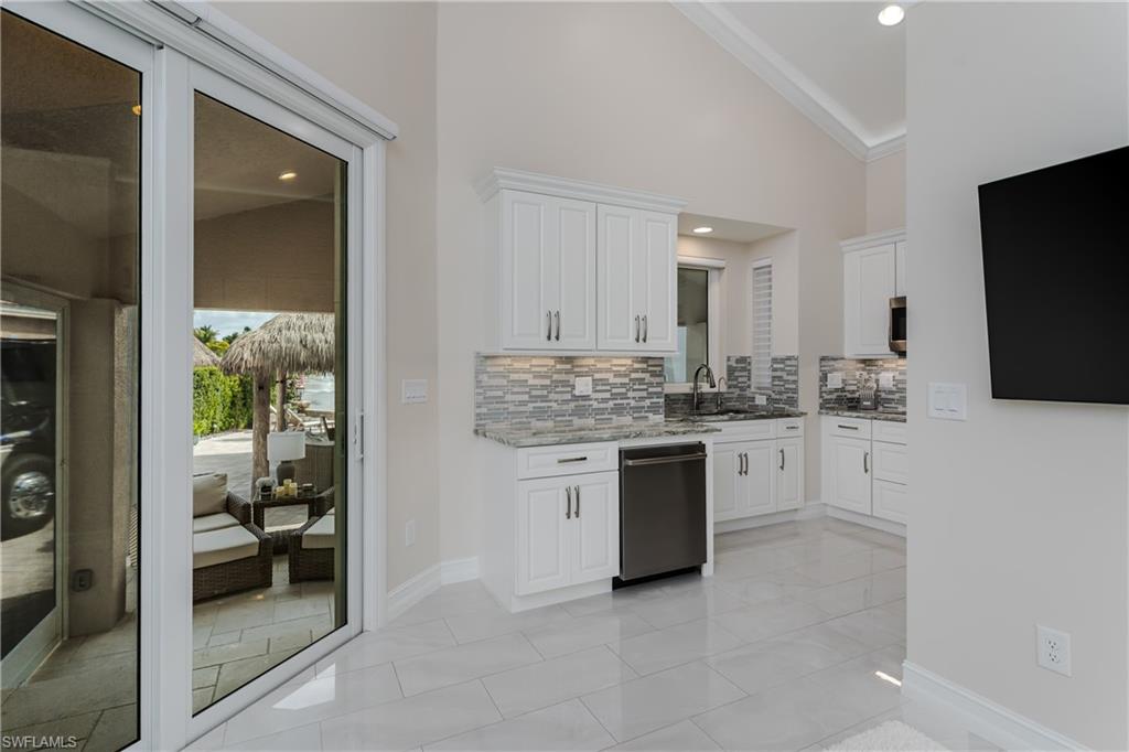 13410 Snook Circle Naples, FL 34114 - Photo 15 of 50 a kitchen with white cabinets and sink